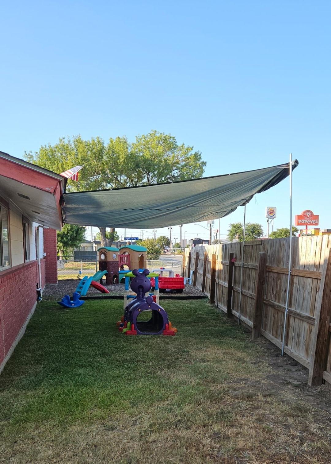 Playground view with a Texas flag, clownfish windsock, and multiple play structures