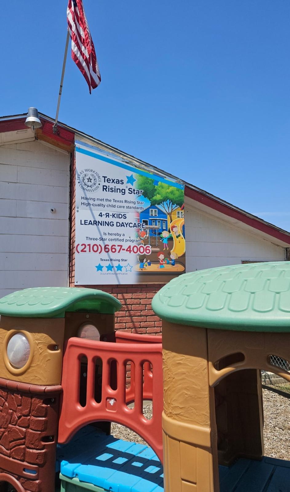 Wooden playset with slide, climbing wall, and Texas flag on a mulch playground